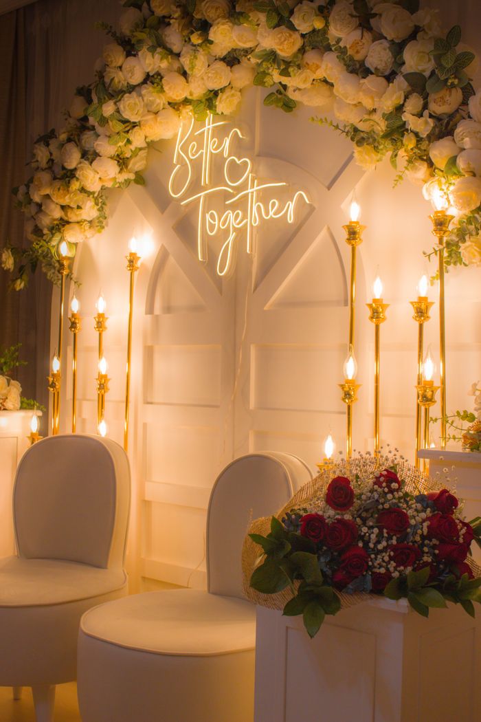 Beautifully decorated wedding ceremony backdrop with flowers and lights.