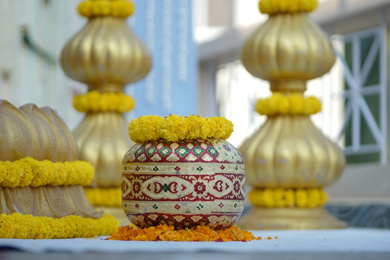 Traditional Indian decorations at a Haldi ceremony featuring marigold flowers and ornate pots.